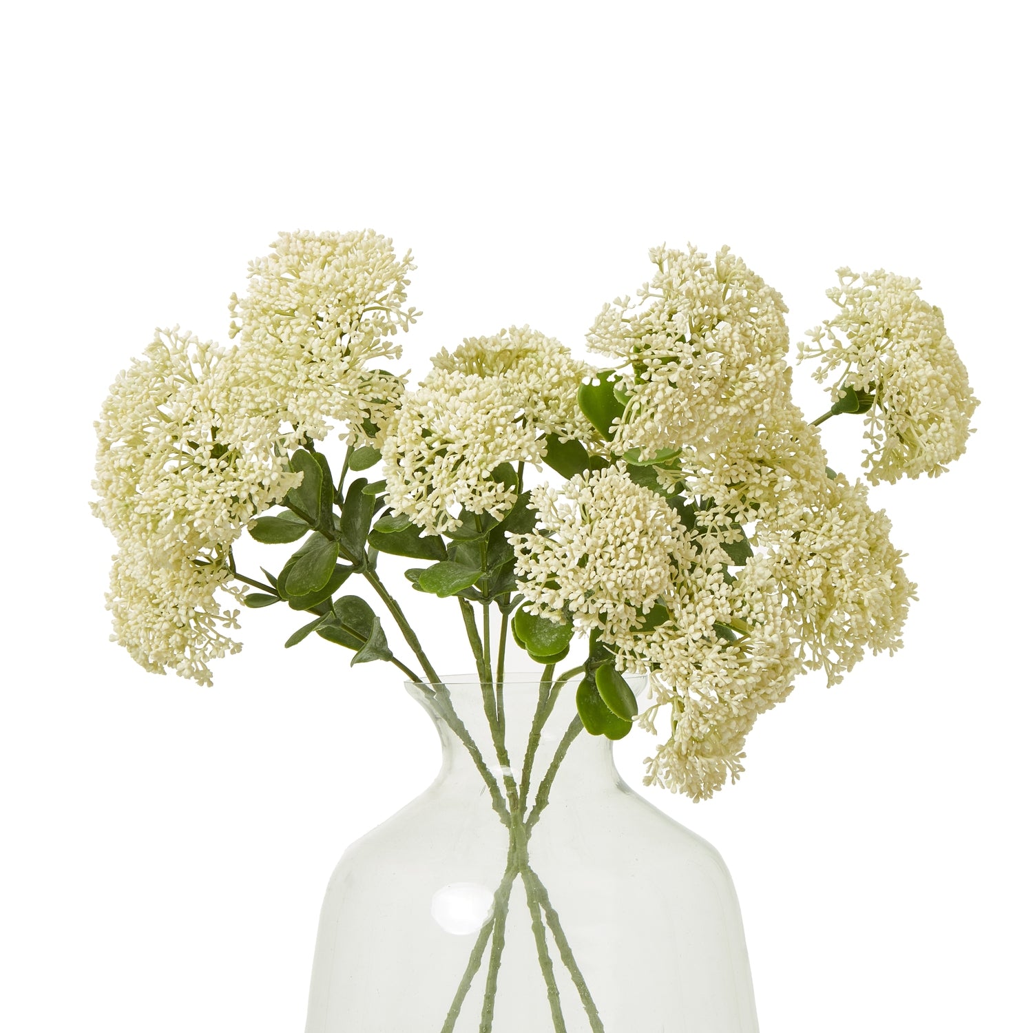 Cream artificial sedum spray with clustered flowers and lush green leaves, arranged in a clear vase for elegant decor.