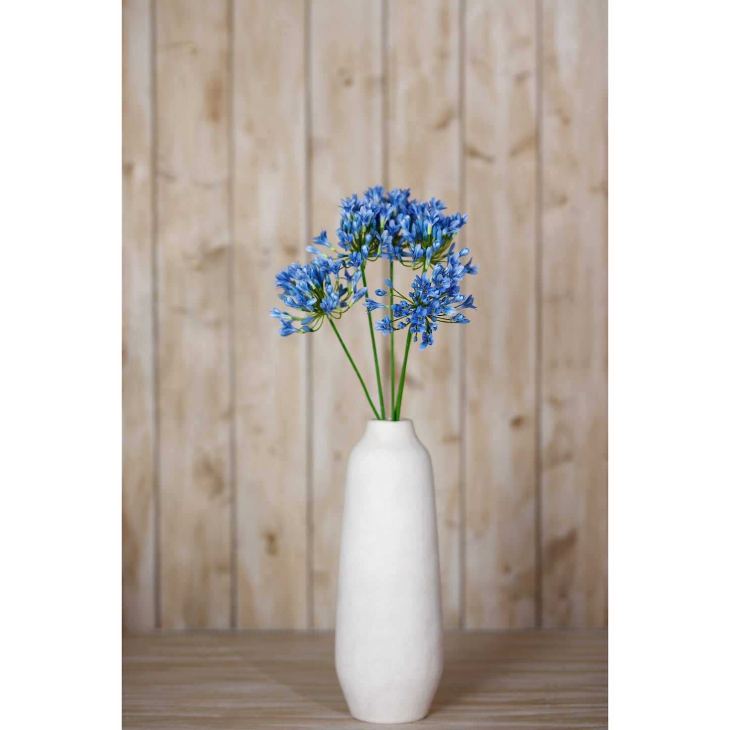 Lifelike blue agapanthus stem in a white vase, featuring vibrant petals, perfect for adding elegance to any decor.
