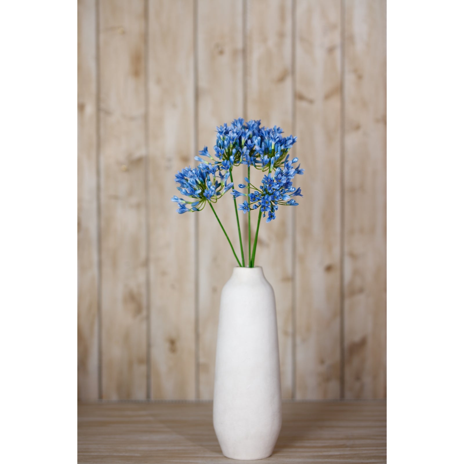 Lifelike blue agapanthus stem in a white vase, featuring vibrant petals, perfect for adding elegance to any decor.