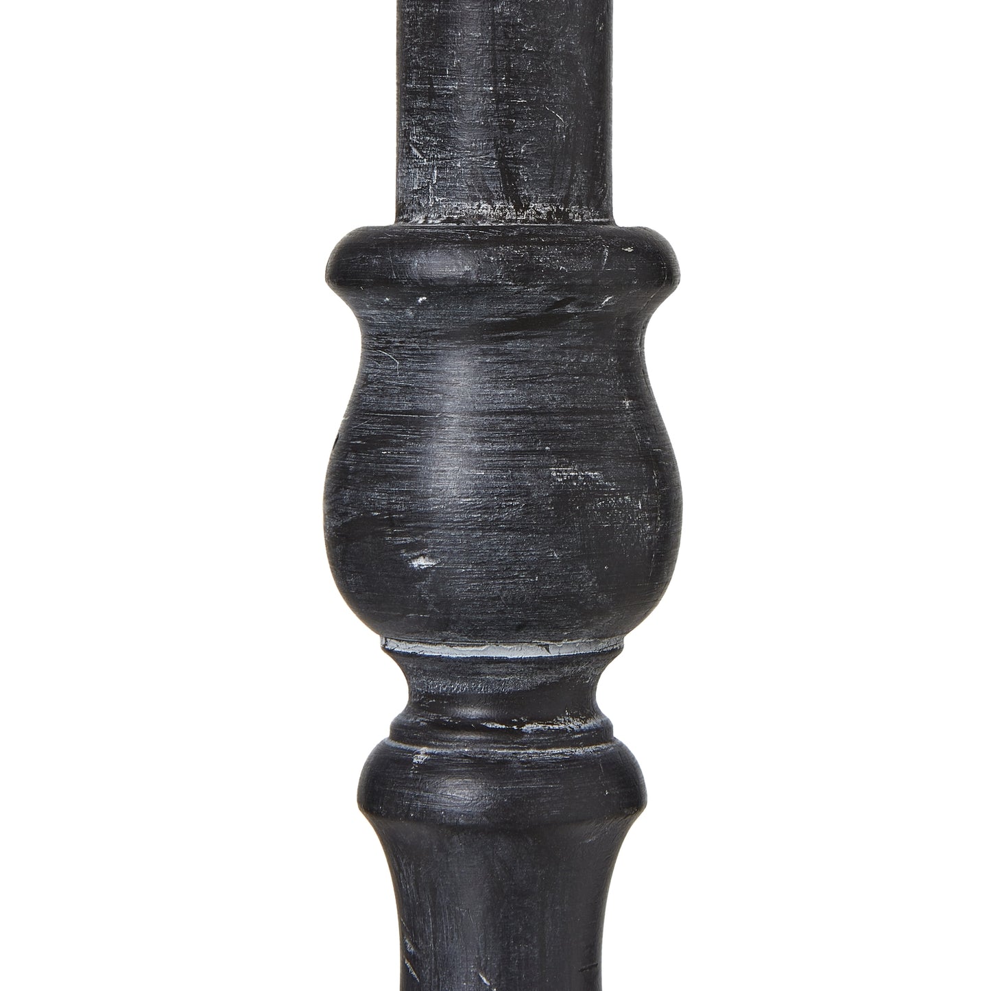 Distressed black base with intricate contours supports a neutral linen shade, enhancing modern or farmhouse interiors.