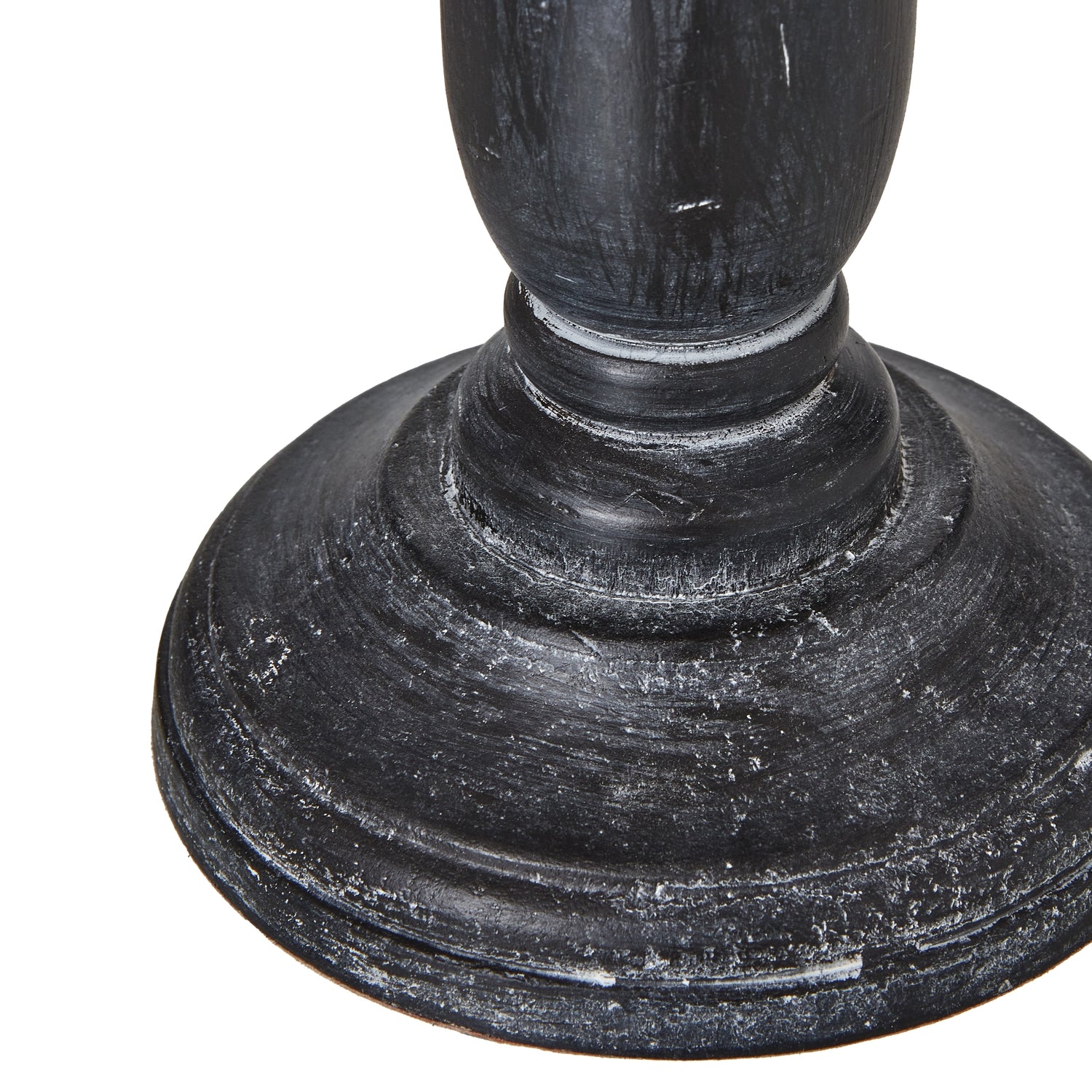 Distressed black base with intricate contours supports a neutral linen shade, creating a sophisticated tabletop lamp.