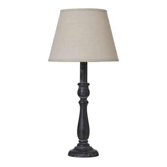 Elegant table lamp with a distressed black base and a neutral linen shade, perfect for modern or farmhouse interiors.