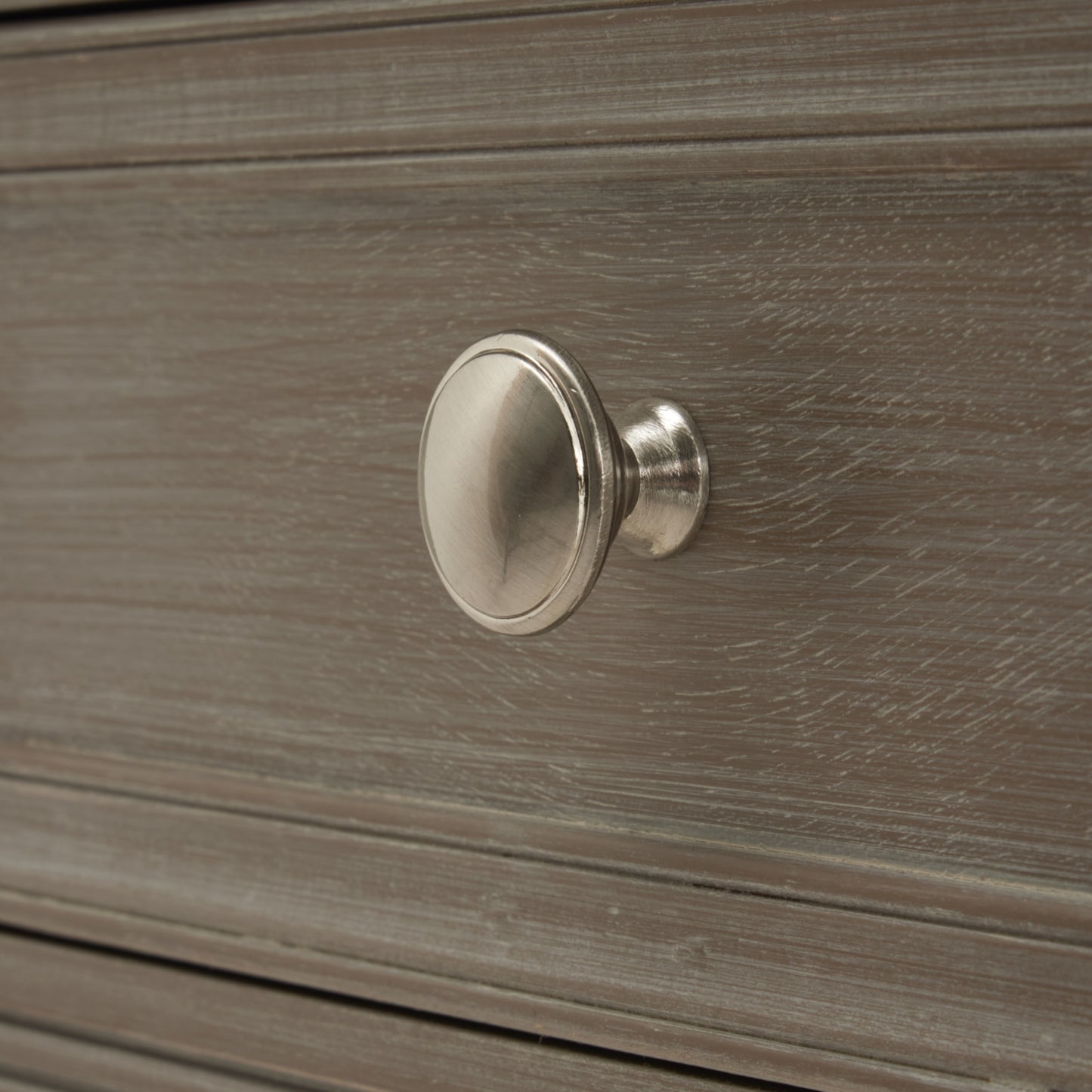 Close-up of a side table drawer in a refined oak finish, featuring a sleek silver knob and subtle wood grain texture.