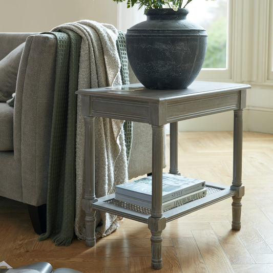 Elegant side table in soft gray with intricate rattan weave and tapered legs; designed for a serene and inviting living space.