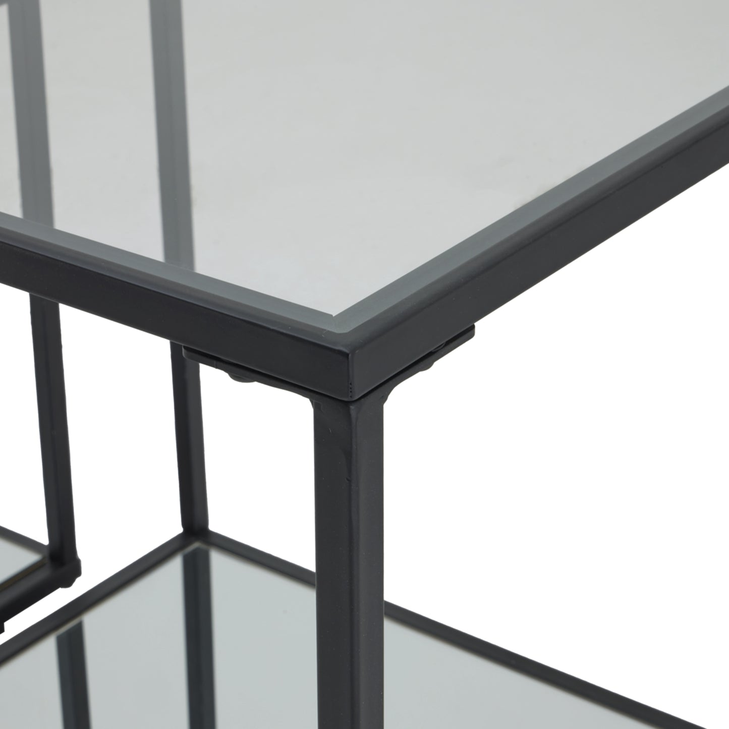 Sleek black framed side tables with glass tops, showcasing a modern design and industrial craftsmanship for versatile use.